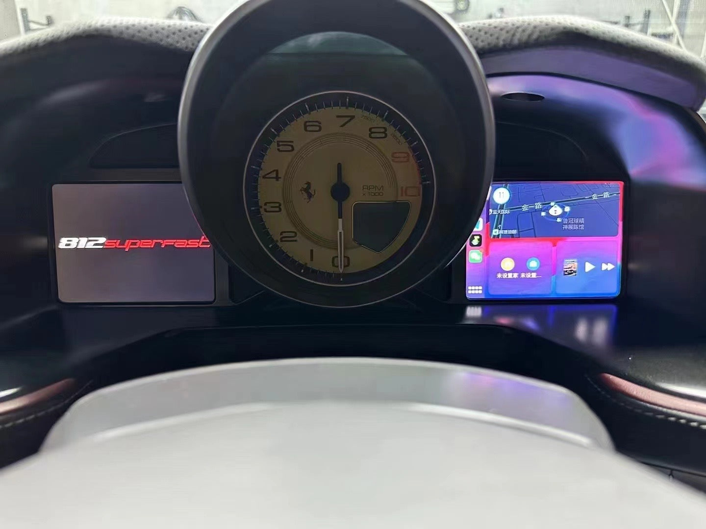 Car dashboard with digital display and steering wheel, featuring '812 Superfast' branding.